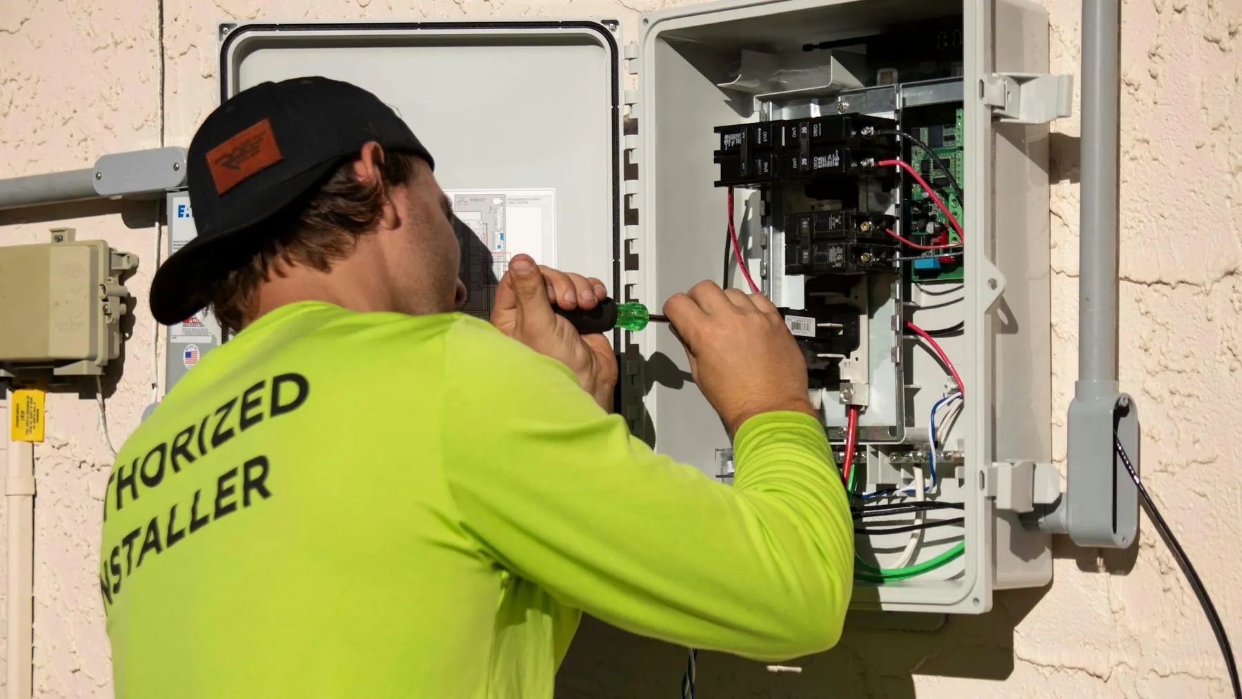 Electrician using a screwdriver to repair an electrical panel